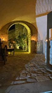 ein Steinzimmer mit Steinboden und einem Torbogen in der Unterkunft Barone Gambadoro in Monte SantʼAngelo