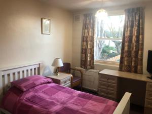 a bedroom with a bed and a desk and a window at St James's House in London