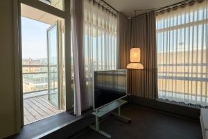 Zimmer mit einem großen Fenster, einem Schreibtisch und einer Lampe in der Unterkunft CPH Hotel in Kopenhagen