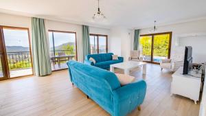ein Wohnzimmer mit einem blauen Sofa und einem Fernseher in der Unterkunft VİLLA KAYA in Kaş