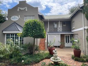 a house with a statue in front of it at Patcham Place in Clarens