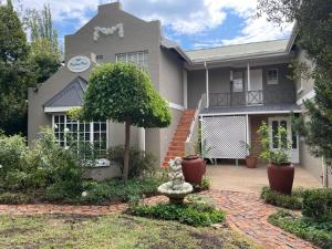 una casa con un árbol en el patio delantero en Patcham Place en Clarens