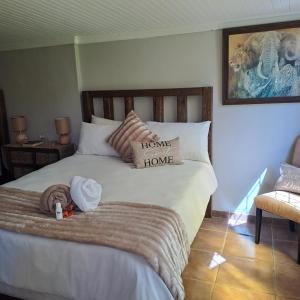 a bedroom with a bed with aelcome home sign on it at Rosies Inn in Piet Retief