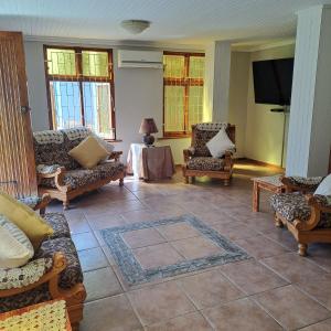 a living room with couches and a table with a tv at Rosies Inn in Piet Retief