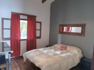 a bedroom with a bed and a window with red curtains at Villa francisca amarilla in La Bolsa