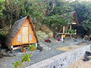 a small house with people standing outside of it at L'Astrolabe - Beach Kubo in Baras