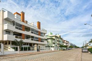 ein Gebäude auf einer Straße mit vor der Tür geparkt in der Unterkunft Sossego e conforto a 600m da praia IDP104 in Florianópolis