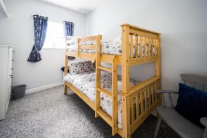 a bedroom with two bunk beds and a window at Meini Glas Mynachlogddu in Mynachlogddu