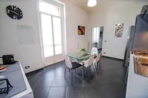 eine Küche mit einem Glastisch und Stühlen im Zimmer in der Unterkunft Appartamento Casa Nizza - Metro Lingotto fiere by Bib's Apartments in Turin