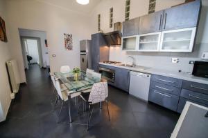 eine Küche mit einem Glastisch und eine Küche mit einem Herd in der Unterkunft Appartamento Casa Nizza - Metro Lingotto fiere by Bib's Apartments in Turin