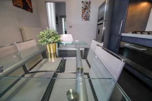 una mesa de cristal con sillas y un jarrón con flores en Appartamento Casa Nizza - Metro Lingotto fiere by Bib's Apartments, en Turín