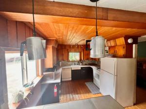 a kitchen with a white refrigerator and two pendant lights at Vintage Downtown Cabin in Squamish