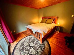 a bedroom with a wooden bed and a rug at Vintage Downtown Cabin in Squamish