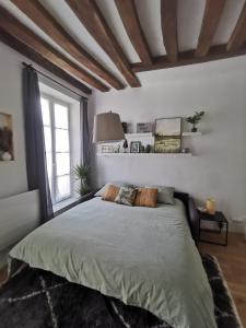 um quarto com uma cama grande e uma janela grande em Saint-Ger, what else ! em Saint-Germain-en-Laye