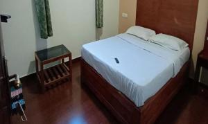 um quarto com uma cama e uma mesa num quarto em FabHotel Sri Guhan EIite em Kodaikānāl