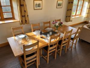 comedor con mesa de madera y sillas en Shircombe Lodge - Exmoor National Park, en Dulverton