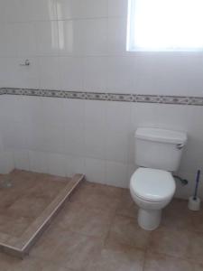 uma casa de banho branca com um WC e uma janela em Blue Waters Villas em Ukunda