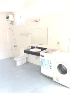 een badkamer met een wasmachine en een wastafel bij Li Homestay 136 Trần Bình, Mỹ Đình, Nam Từ Liêm, Hà Nội in Hanoi