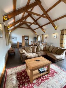a living room with a couch and a table at Shircombe Lodge - Exmoor National Park in Dulverton