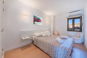 a white bedroom with a bed and a chair at NEW Seaview Ap Anita by JS Villas in Port de Pollensa