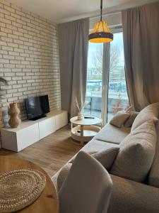 a living room with a couch and a tv at Baltic Marina Residence z mini SPA in Kołobrzeg
