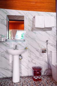 a white marble bathroom with a sink and a mirror at Tam Coc Cat Luong Homestay in Ninh Binh