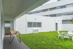 un edificio blanco con patio con mesa y sillas en Casa verde, en Ribeira Grande