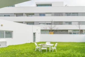a table and chairs on a lawn in front of a building at Casa verde in Ribeira Grande
