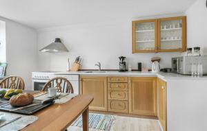 a kitchen with wooden cabinets and a table with a bowl of fruit at 3 Bedroom Lovely Apartment In Engesvang in Engesvang