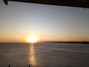 un tramonto sull'acqua con il tramonto di Hostel Guaratiba Casa do Café a Barra de Guaratiba