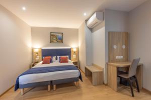 a bedroom with a bed and a desk and a chair at Hotel Saint Augustin in Strasbourg