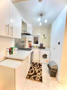 a kitchen with white cabinets and a washer and dryer at Great Studio flat in Central London in London