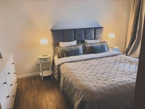 a bedroom with a large bed with a blue headboard at Baltic Marina Residence z mini SPA in Kołobrzeg