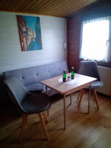 a table and two chairs with two bottles on it at FEWO Isla 2 in Elmenhorst