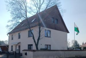 uma casa branca com uma bandeira em frente em Vermietung Hänsel em Thiendorf