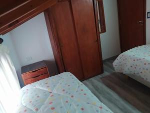 1 dormitorio con 1 cama con sábanas de lunares en Departamentos Familiares Rosas Rojas en Villa Gesell