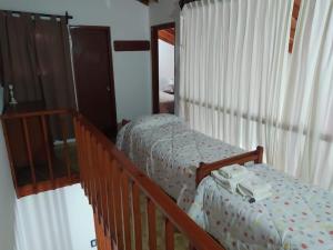 1 dormitorio con 2 camas individuales y escalera en Departamentos Familiares Rosas Rojas en Villa Gesell