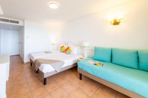 - une chambre avec un lit et un canapé dans l'établissement Résidence Pierre & Vacances Premium Les Tamarins, à Sainte-Anne