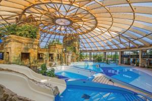 a large swimming pool in a building with a ceiling at Király Családi Apartman- Royal Family Apartment in Budapest