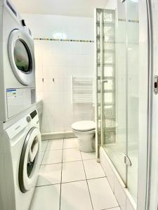 ein Badezimmer mit einer Waschmaschine und einem WC in der Unterkunft Grand appartement cosy avec balcon 6 personnes in Saint-Ouen