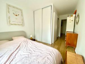 ein Schlafzimmer mit einem Bett, einer Kommode und einer Tür in der Unterkunft Grand appartement cosy avec balcon 6 personnes in Saint-Ouen