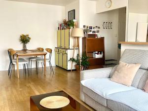 ein Wohnzimmer mit einem Sofa und einem Tisch in der Unterkunft Grand appartement cosy avec balcon 6 personnes in Saint-Ouen