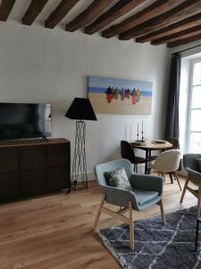 uma sala de estar com uma cadeira e uma mesa em Saint-Ger, what else ! em Saint-Germain-en-Laye