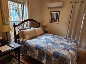 薩默維爾的住宿－Davis Square Inn，一间卧室配有一张床、一张桌子和一个窗户。