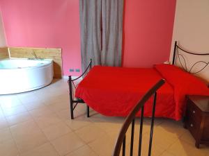 カターニアにあるCatania a 2 passi dal Duomoのベッドルーム(赤いベッド1台、バスタブ付)