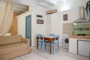 a kitchen with a table and chairs and a couch at Appartamento a Ortigia in Syracuse