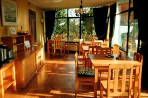 a restaurant with wooden tables and chairs and windows at Hotel Seminario in Puerto Montt