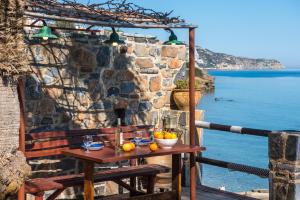 un tavolo con un cesto di frutta su un balcone affacciato sull'oceano di The Spot on the Beach by Michael a Palaiokastro