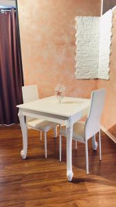 mesa de comedor blanca y 2 sillas blancas en Castelpetroso Bed&Breakfast, en Castelpetroso