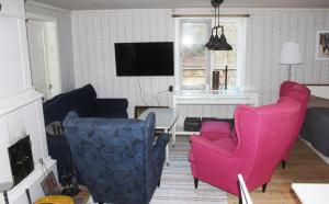 a living room with pink chairs and a tv at Cozy holiday home in Tranas, Odeshog in Tranås